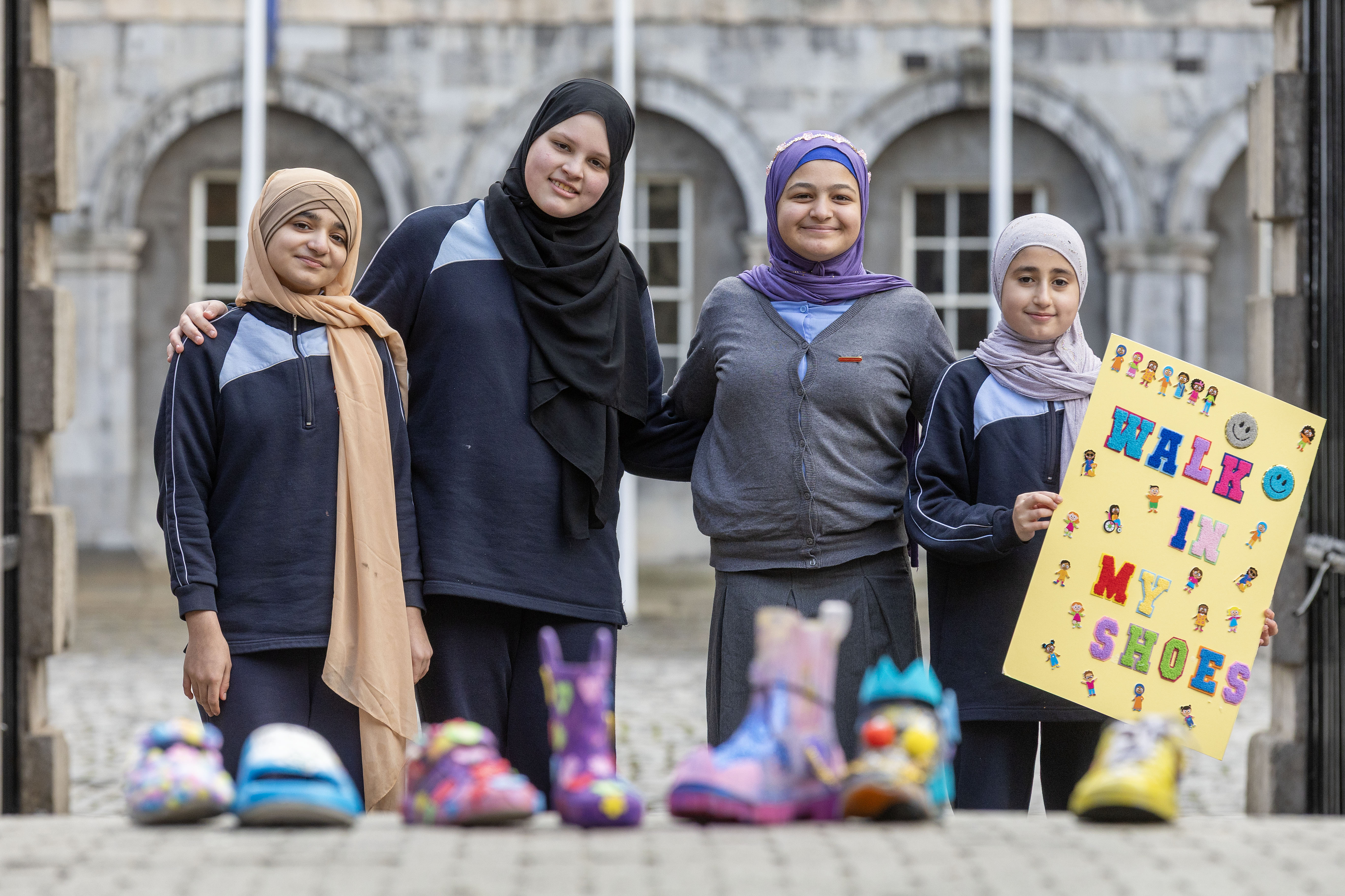 Pupils from Muslim National School smile and pose with their project Walk In My Shoes