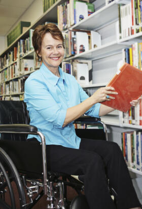 Female wheelchair user in a library
