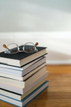 Pile of reports with glasses resting on top