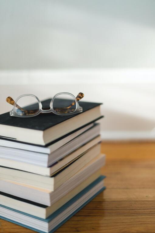 Pile of books with glasses sitting on top