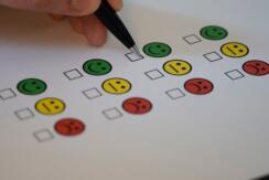 Survey capturing feedback using three colours of emoji faces, green yellow and red