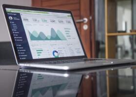 A laptop on a table with graphs on the screen